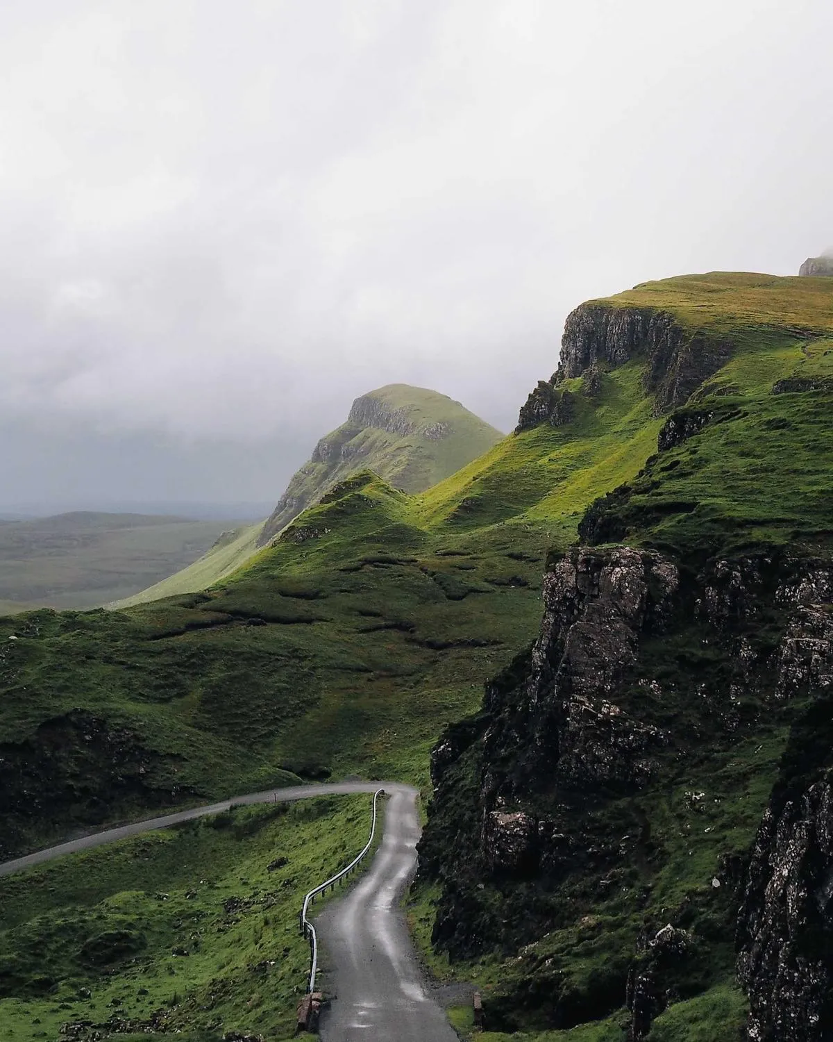Winding mountain road through green valleys and hillsides, placeholder for tour-country photography